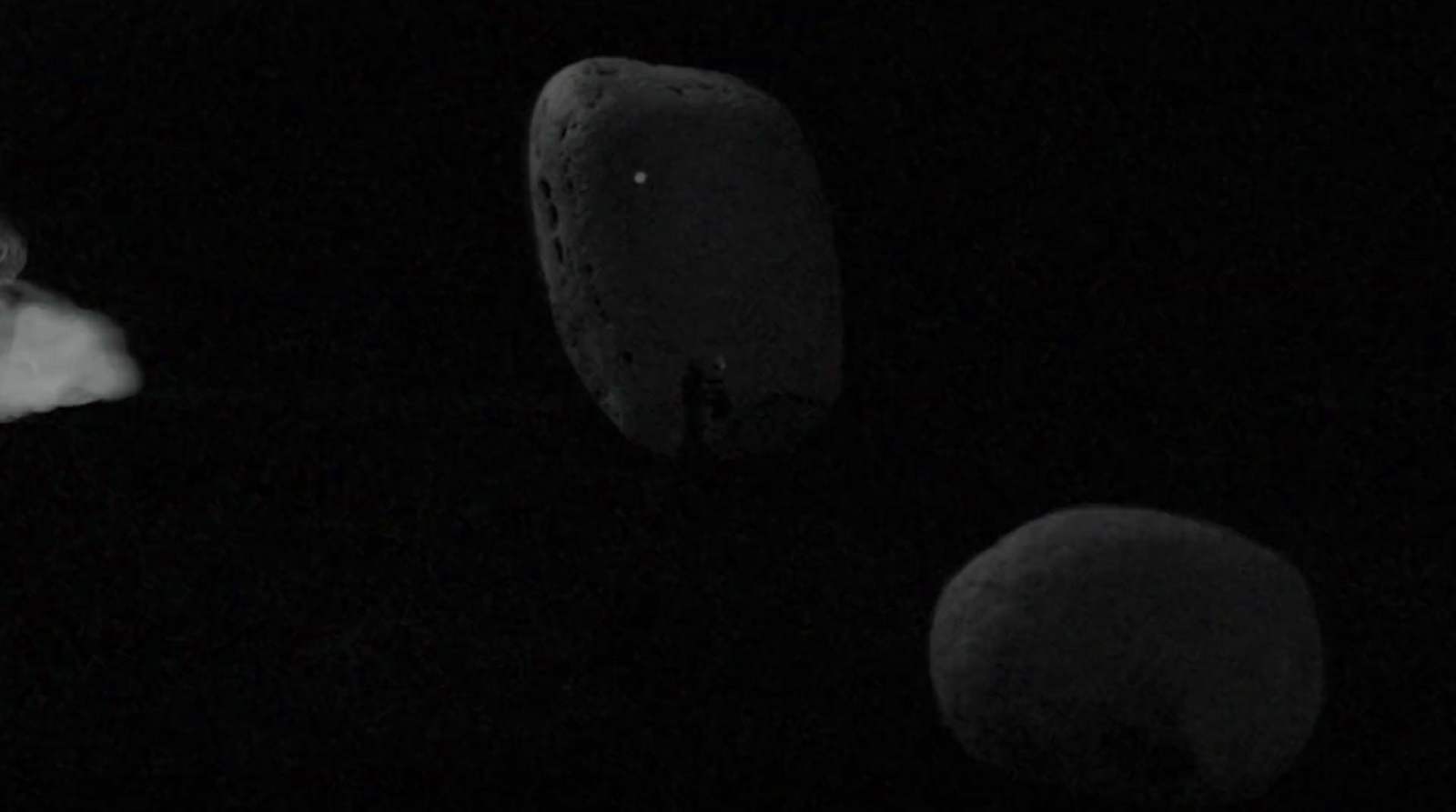 a black and white photo of two objects in the dark