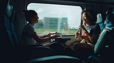 a couple of people sitting on a train next to each other