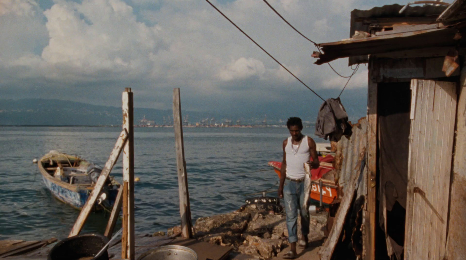 a man standing next to a boat on a body of water