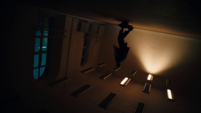 a person jumping up into the air in a dark room