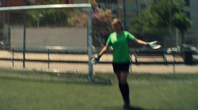 a woman in a green shirt is playing soccer