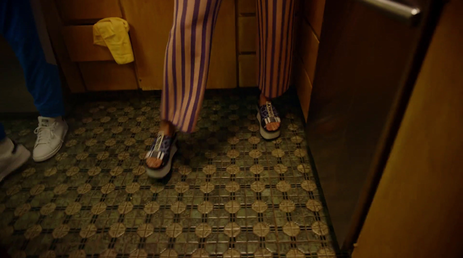 a person in striped pants standing in a kitchen