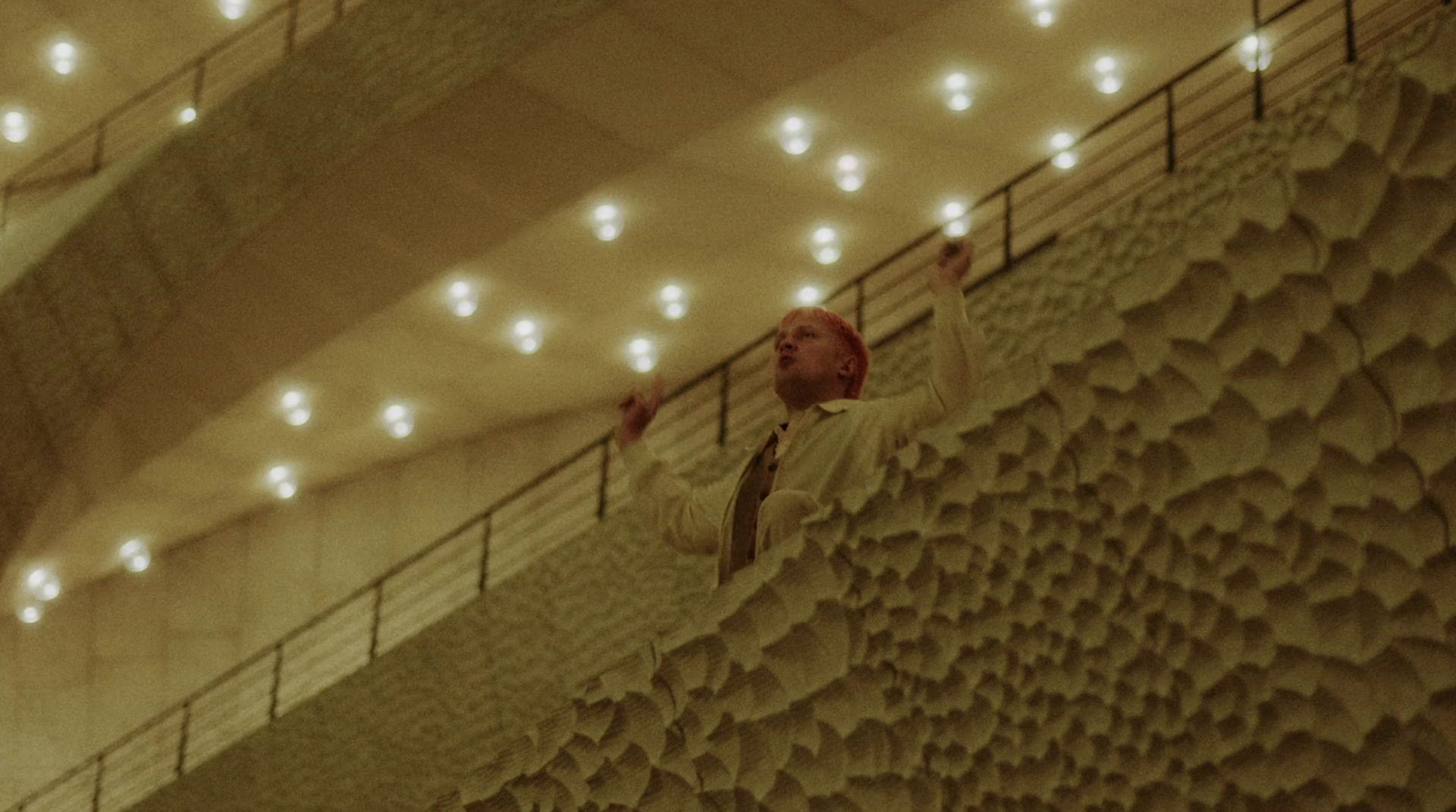 a man standing on a balcony next to a railing