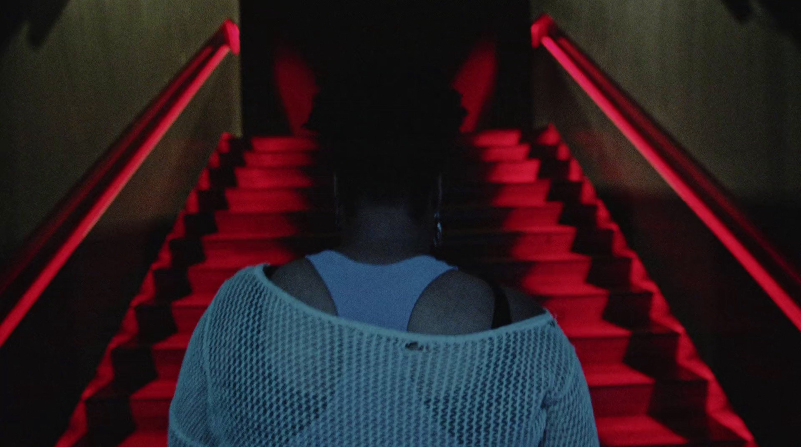 a woman standing in front of a red staircase