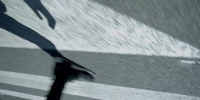 a shadow of a person walking down a street