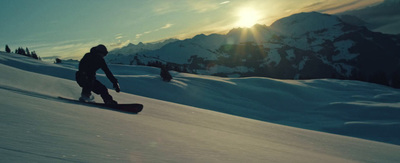 a man riding a snowboard down a snow covered slope