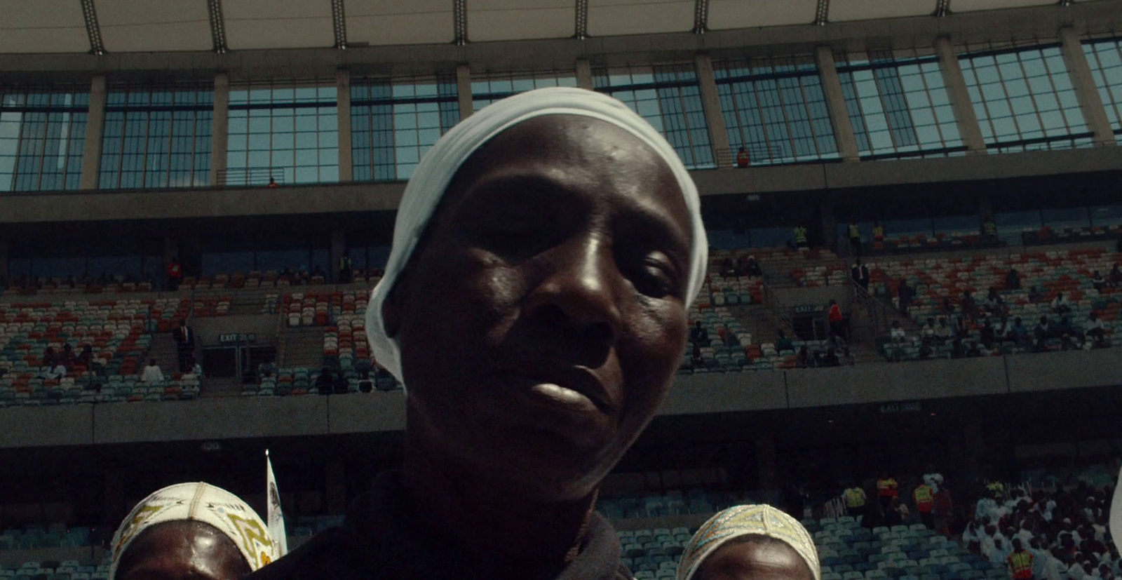 a woman with a towel on her head standing in front of a crowd