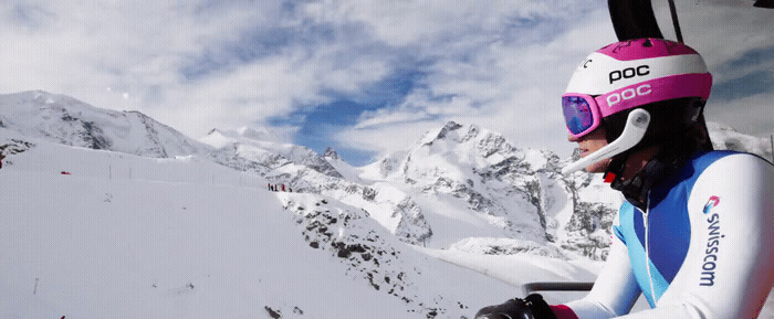 a woman riding a ski lift down a snow covered slope