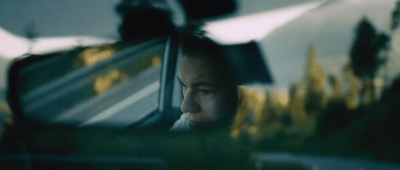 a man sitting in a car looking out the window