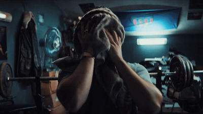 a man holding his hands to his face in front of a barbell