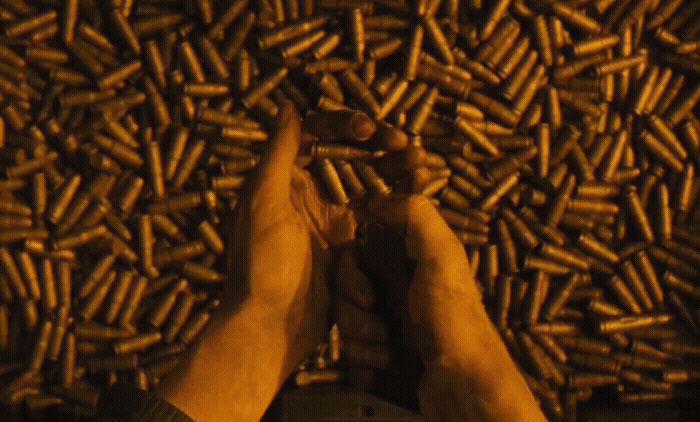 a person standing in front of a pile of bullet shells