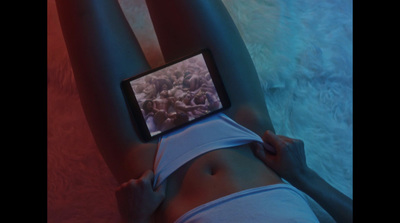 a woman laying down with a cell phone on her stomach