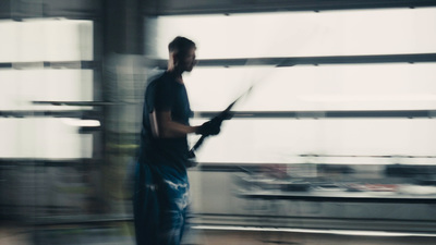 a man is walking in an airport with a plane in the background