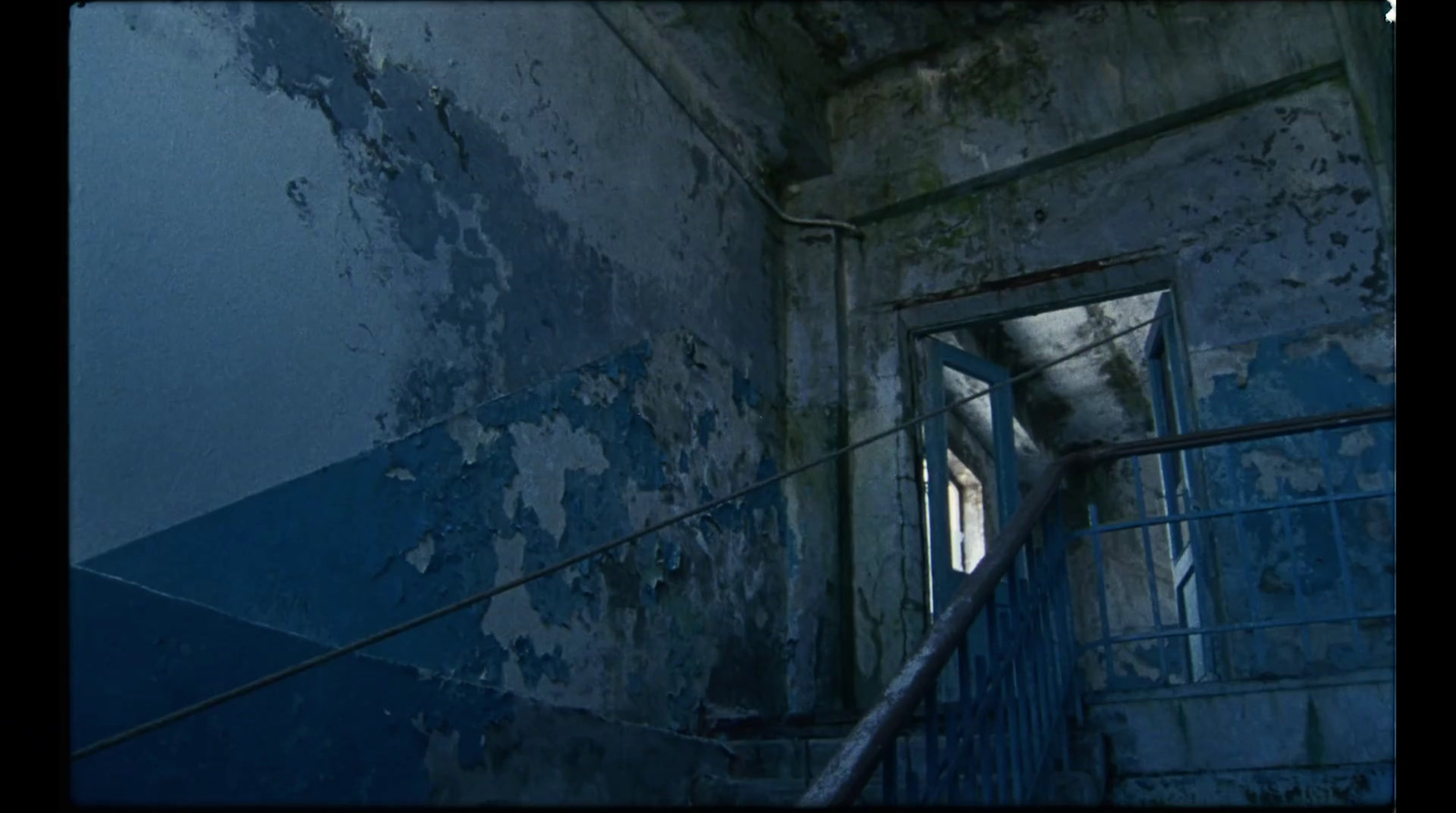 a stairway leading to a window in a run down building