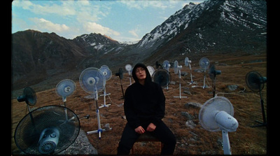 a man sitting on a chair in front of a mountain