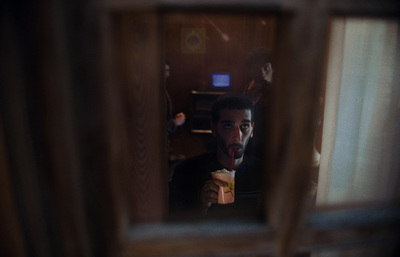 a man eating a sandwich in front of a mirror