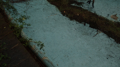 a fenced in area with grass and dirt on the ground