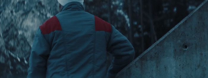 a man in a blue and red jacket walking up a flight of stairs