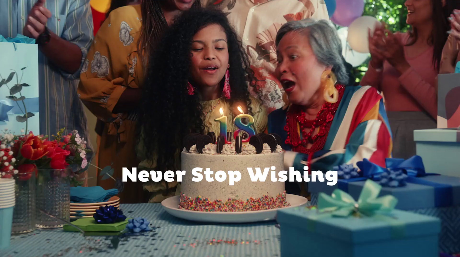 a group of people standing around a birthday cake