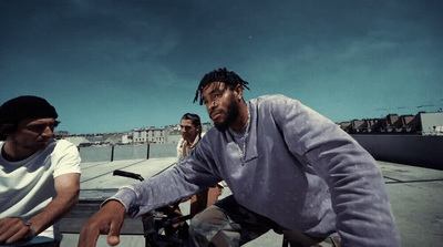 a man riding a bike next to another man on a skateboard