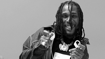 a black and white photo of a man with dreadlocks