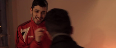 a man in a red jacket is talking to another man