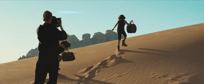 a couple of people walking across a desert