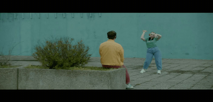 a man standing next to a woman on a sidewalk