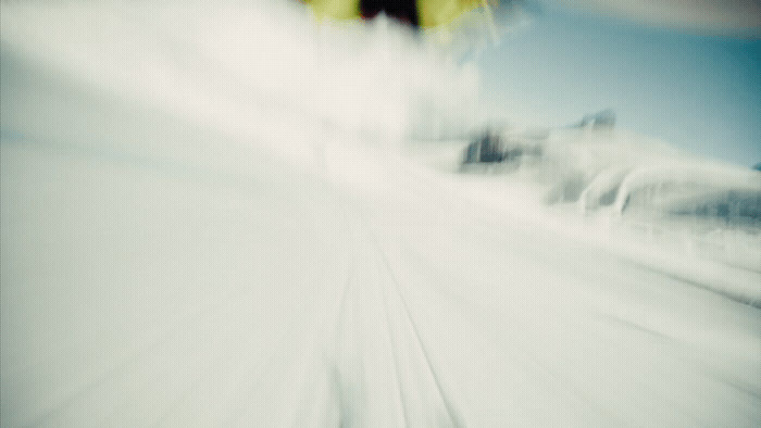 a blurry photo of a snowboarder going down a hill