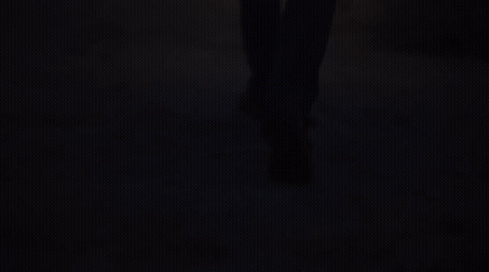 a person standing in the dark holding a cell phone