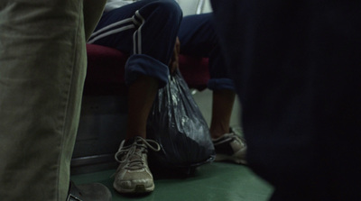 a person sitting on a bench with a bag