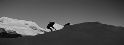 a man riding a snowboard down a snow covered slope