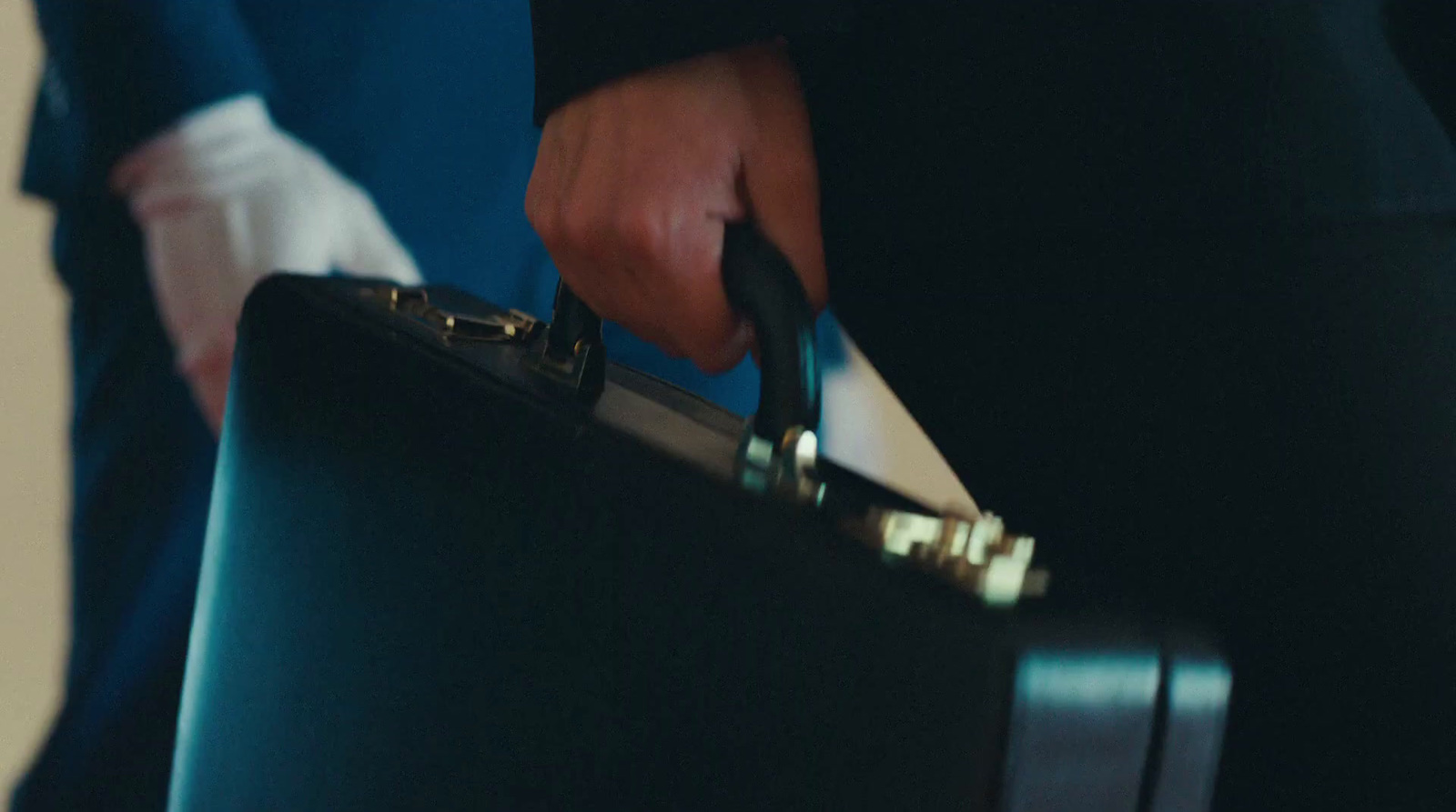 a close up of a person holding a suit case