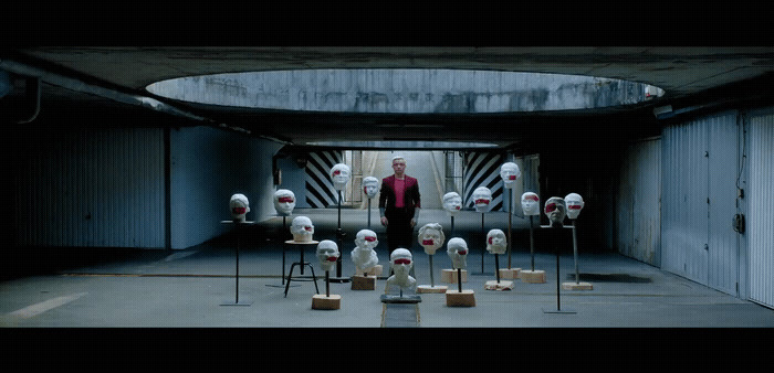 a man standing in front of a bunch of fake heads