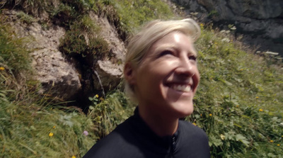 a woman standing in front of a rocky cliff