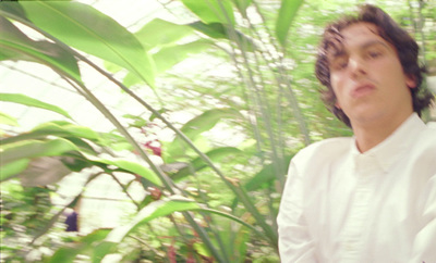 a man standing in front of a lush green forest