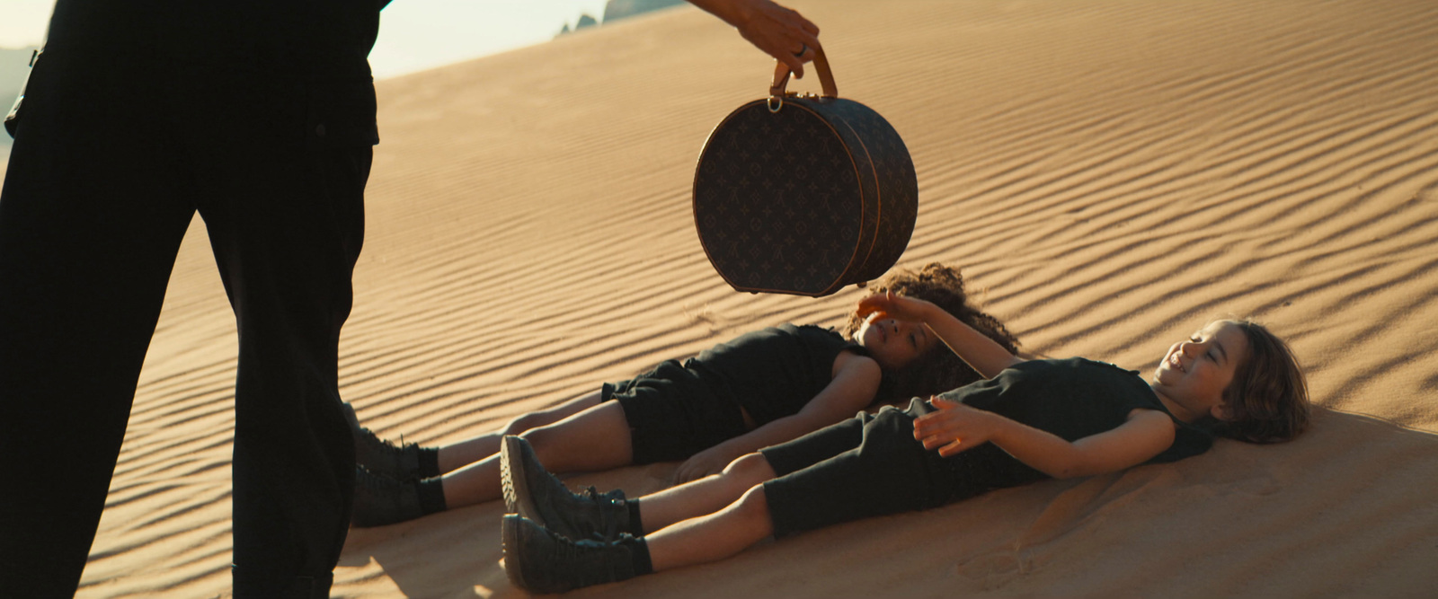 a woman is laying on the sand with a hat on her head