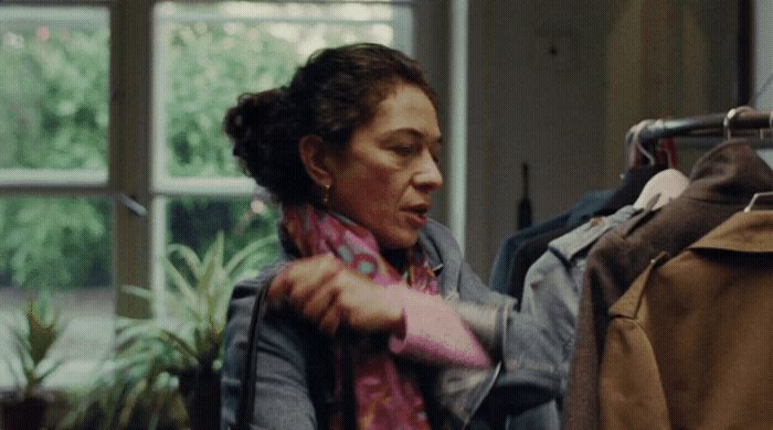 a woman looking at clothes hanging on a rack