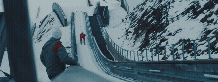 a man riding a snowboard down a snow covered slope