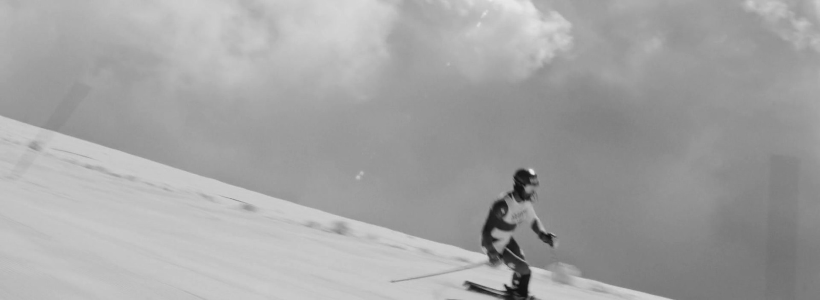 a man riding skis down a snow covered slope