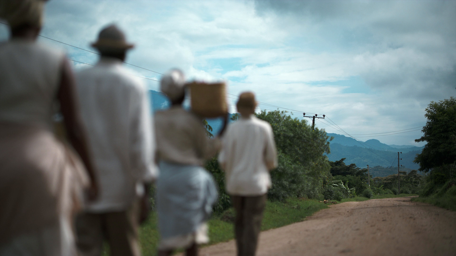 a group of people walking down a dirt road