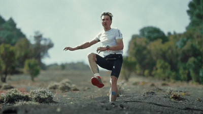 a man kicking a soccer ball in a field