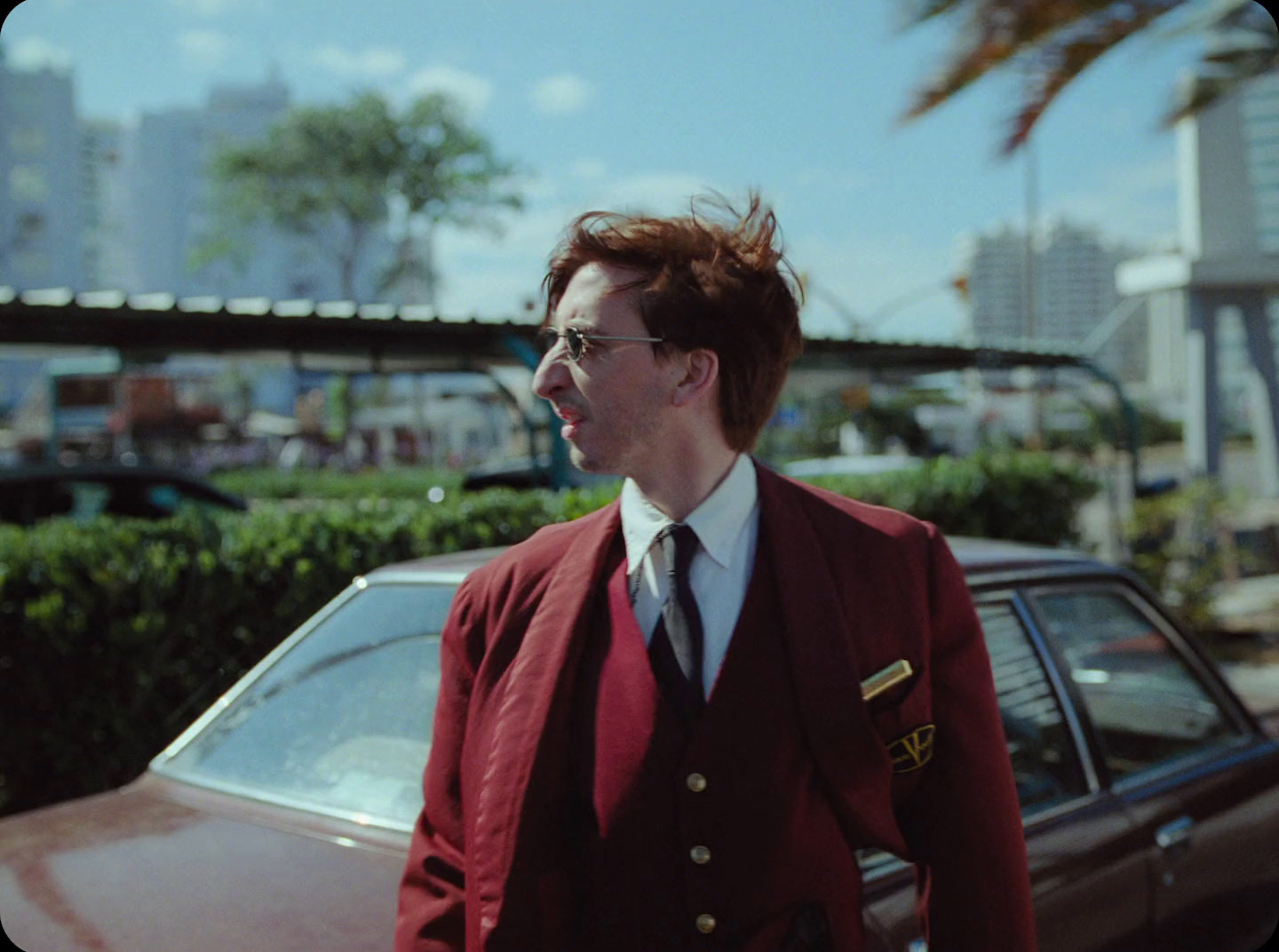 a man in a suit and tie standing next to a car