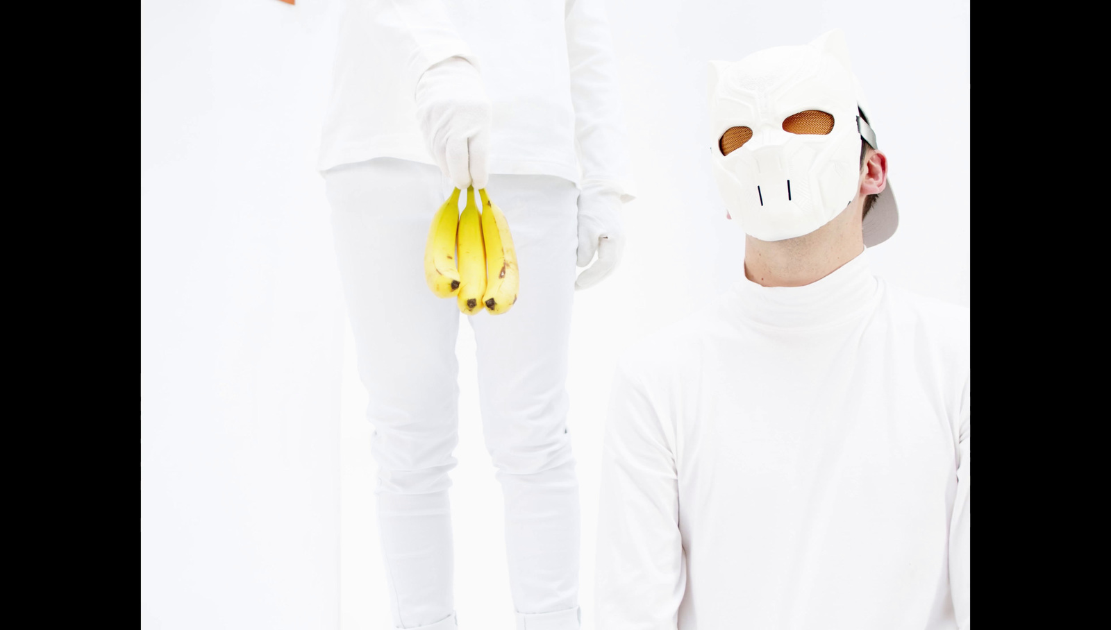 a man wearing a mask and holding a bunch of bananas