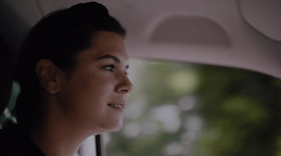 a woman sitting in a car looking out the window