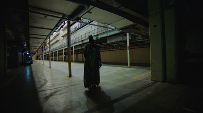 a person standing in an empty parking garage