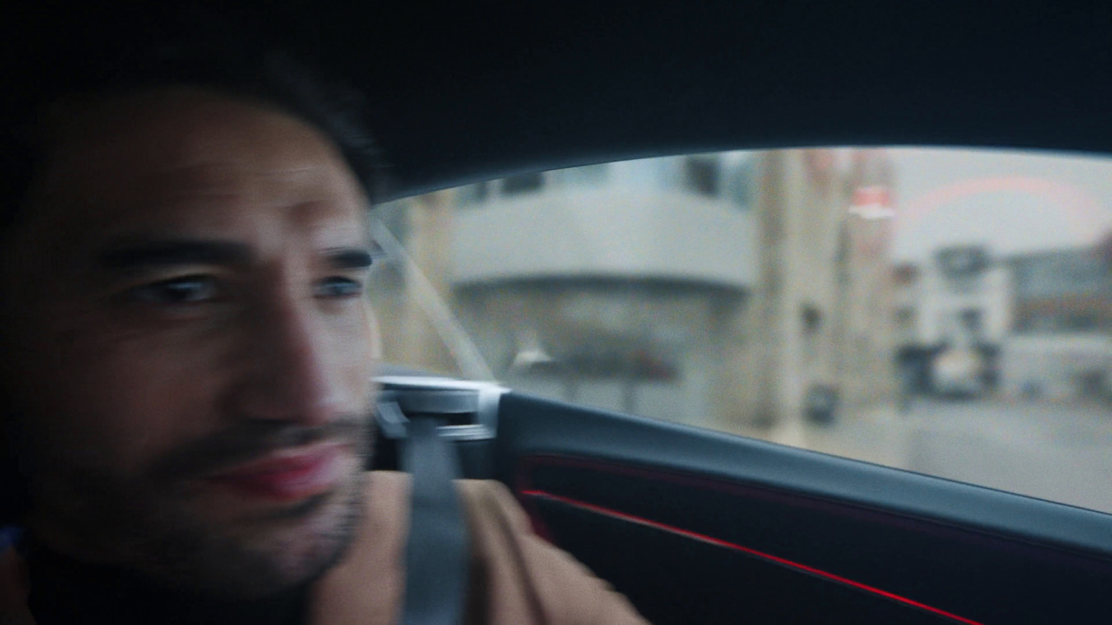 a man driving a car on a city street