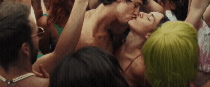 a man and woman kissing in a crowd of people