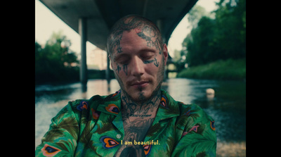 a man with tattoos on his face and neck