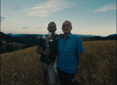 a couple of men standing next to each other in a field